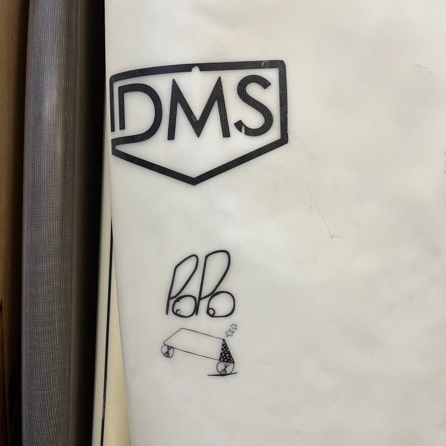 DMS Popo 5'9" secondhand surfboard brand logo close-up