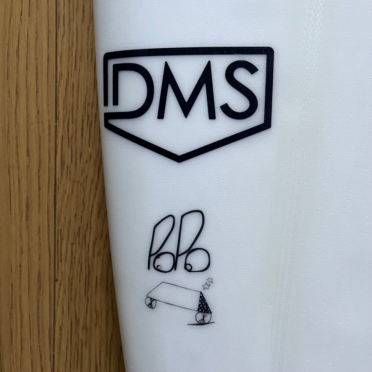 DMS Popo 6'0" secondhand surfboard brand logo close-up